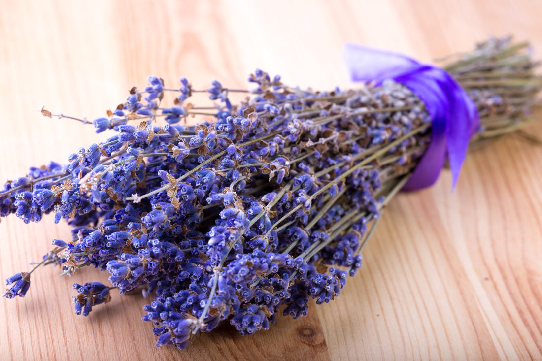 Purple lavender bouquet with purple bow on wooden table 