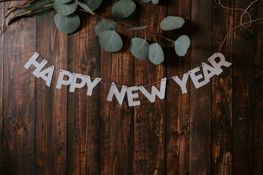 Happy New Year spelled out in paper cut out letters on wooden table 