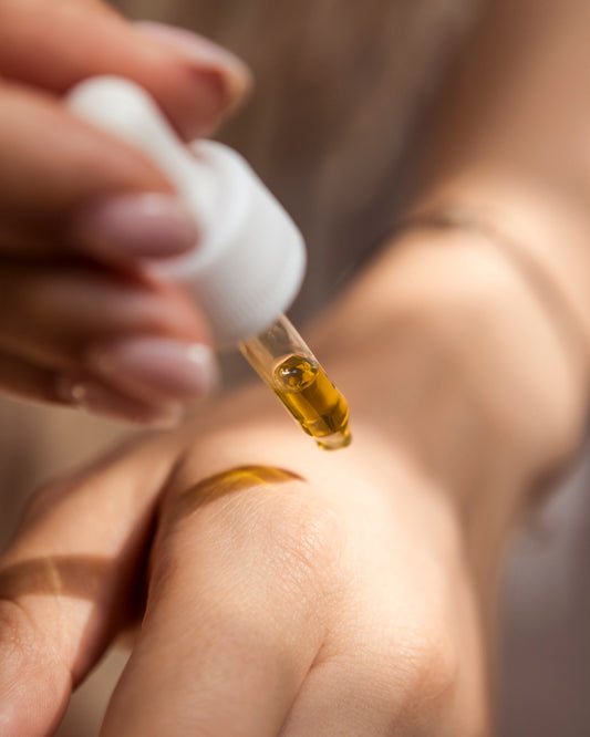 close up of wrist and hand applying drops from dropper